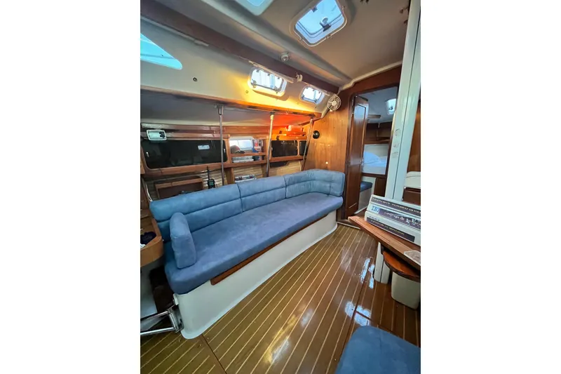 Slide: The Image of Interior of 1996 Catalina 400 yacht with blue seating and wooden flooring. - 54