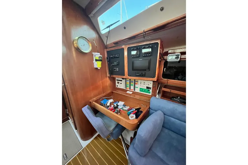Slide: The Image of Navigation station inside 1996 Catalina 400 sailboat with control panels and equipment. - 56