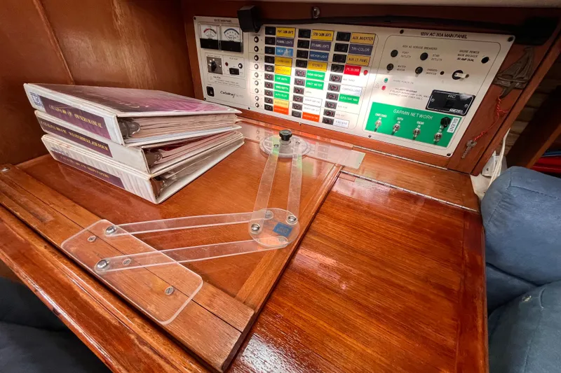Slide: The Image of Navigation station of a 1996 Catalina 400 sailboat with control panel and charts. - 67
