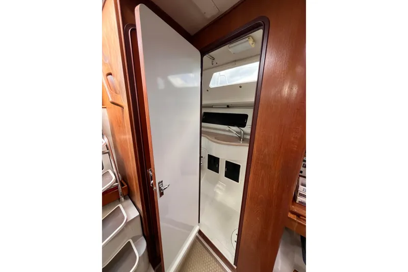 Slide: The Image of Interior view of 1996 Catalina 400 sailboat cabin with wooden door and compact design. - 71