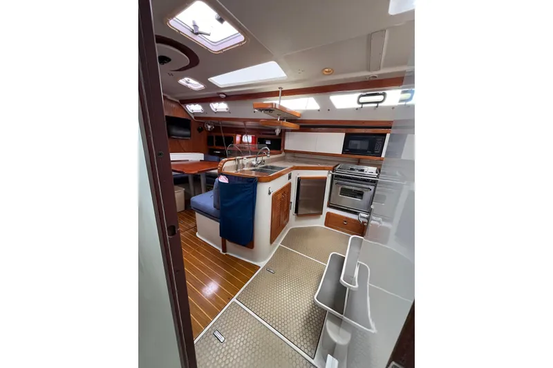 Slide: The Image of Interior of a 1996 Catalina 400 sailboat with modern kitchen and seating area. - 74