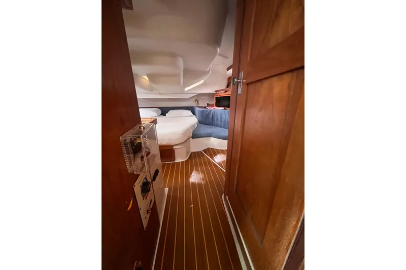 Slide: The Image of Interior view of 1996 Catalina 400 sailboat cabin with wooden flooring and cozy bed. - 75