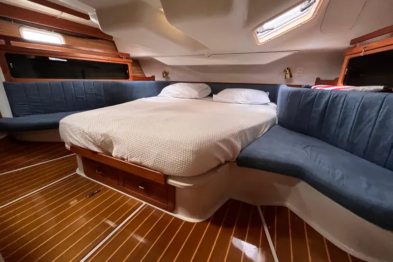 Slide: The Image of Cozy cabin interior of 1996 Catalina 400 sailboat with wood flooring and plush seating. - 78