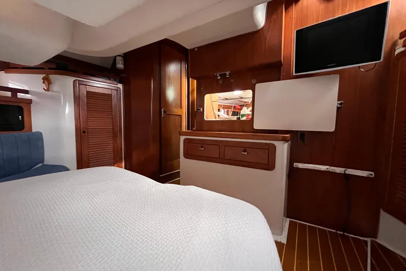Slide: The Image of Interior of a 1996 Catalina 400 yacht cabin with wood paneling and modern amenities. - 80