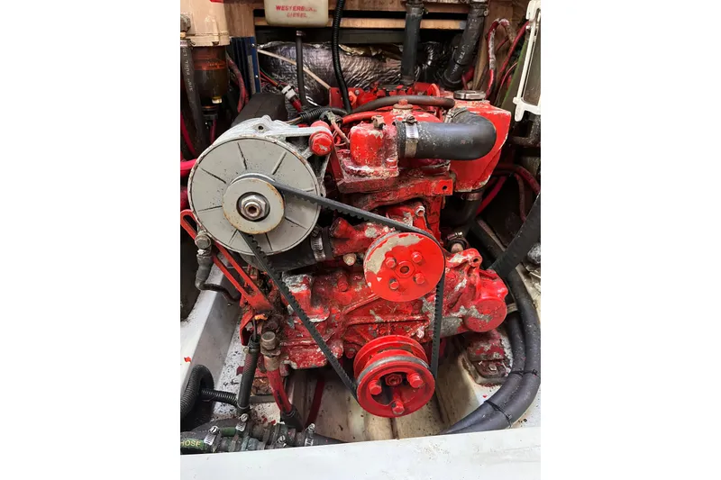 Slide: The Image of Red engine of a 1996 Catalina 400 sailboat, featuring belts and hoses. - 85