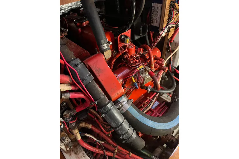 Slide: The Image of Engine compartment of a 1996 Catalina 400 sailboat, featuring red wiring and hoses. - 86