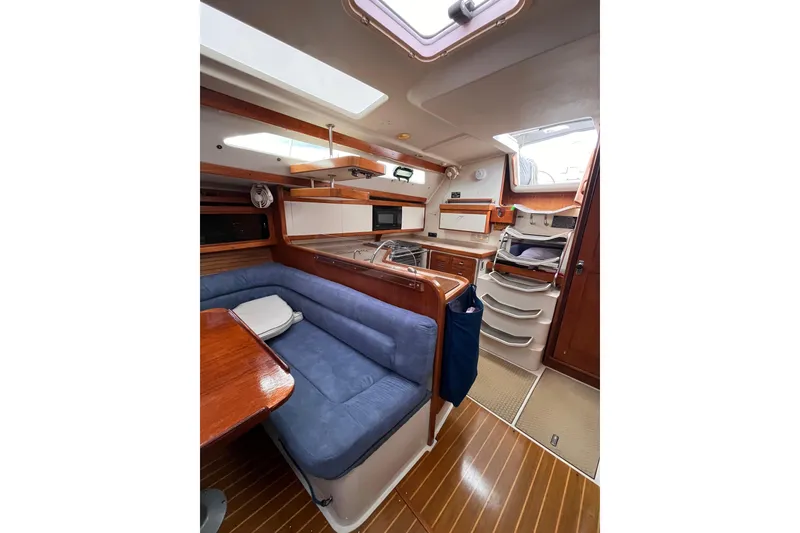 Slide: The Image of Interior of a 1996 Catalina 400 sailboat with cozy seating and wooden finishes. - 89