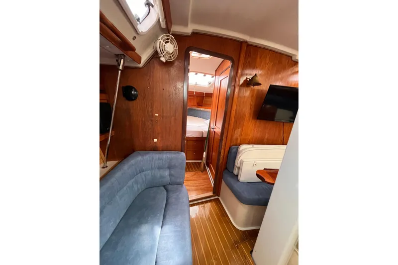 Slide: The Image of Interior of 1996 Catalina 400 sailboat with wood paneling and blue seating. - 90