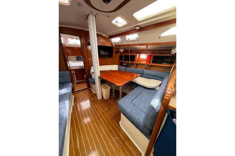 Slide: The Image of Interior of 1996 Catalina 400 sailboat with wooden flooring and cozy seating area. - 92