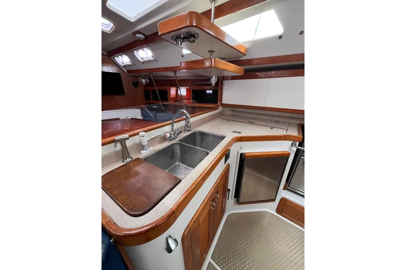 Slide: The Image of Interior of 1996 Catalina 400 yacht kitchen with sink, wooden cabinets, and modern appliances. - 94