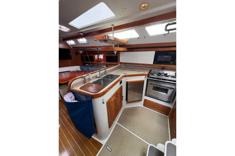Slide: The Image of Interior of 1996 Catalina 400 yacht kitchen with modern appliances and wooden accents. - 95