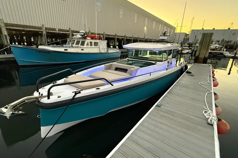 Slide: The Image of 2024 Axopar 37 boat docked at marina during sunset. - 1
