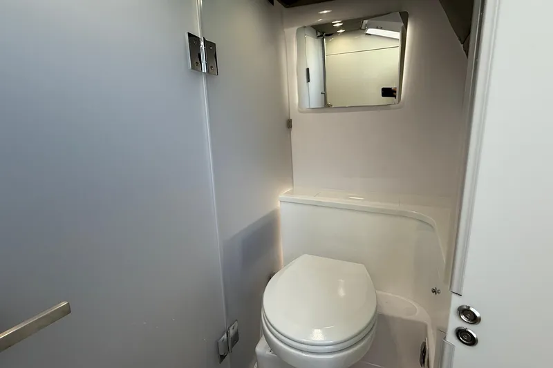 Slide: The Image of 2024 Axopar 37 boat bathroom interior with modern fixtures and mirror. - 14