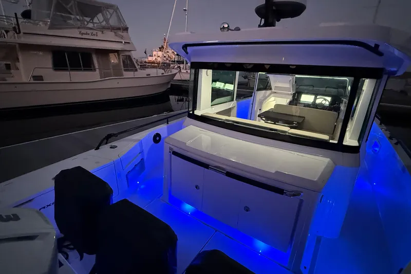 Slide: The Image of 2024 Axopar 37 boat with illuminated interior and sleek design at dusk. - 15