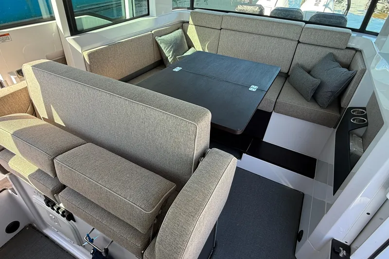 Slide: The Image of 2024 Axopar 37 interior with cushioned seating and foldable table. - 23