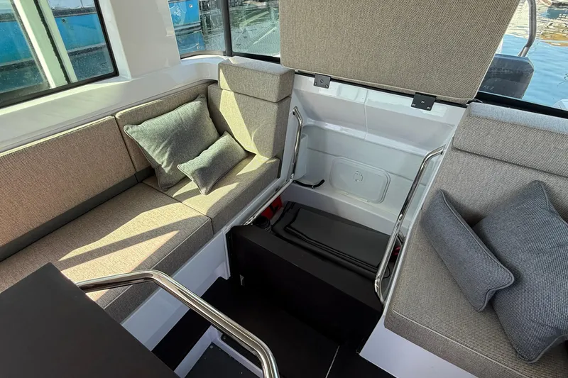Slide: The Image of 2024 Axopar 37 interior seating area with cushions and storage compartment. - 28