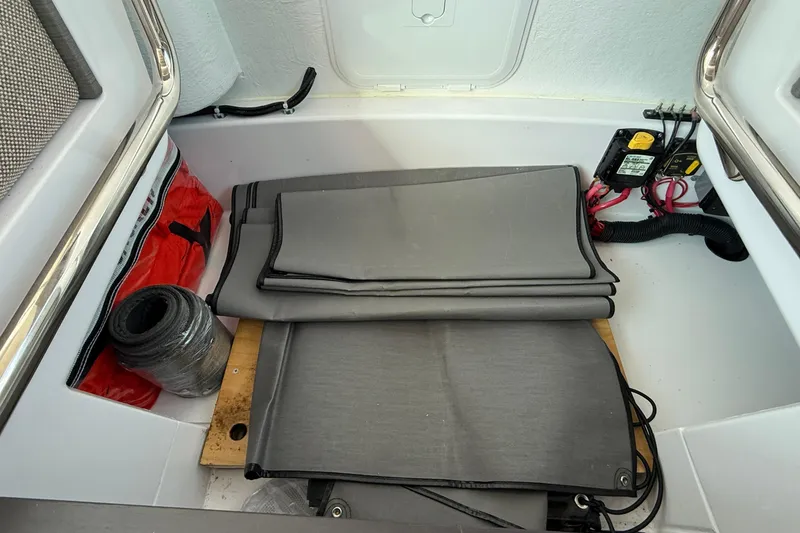Slide: The Image of Storage compartment of 2024 Axopar 37 boat with folded mats and equipment. - 29