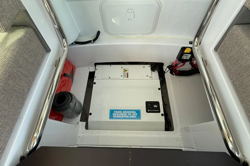 Slide: The Image of 2024 Axopar 37 boat storage compartment with Seakeeper unit and safety equipment. - 31