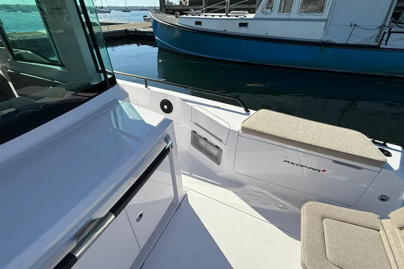 Slide: The Image of 2024 Axopar 37 boat interior with seating, docked near water. - 34