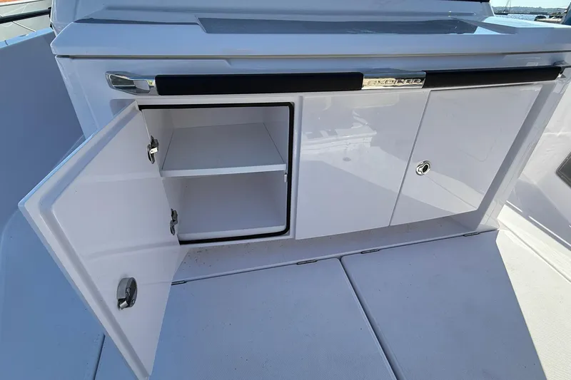 Slide: The Image of 2024 Axopar 37 boat storage compartment with open cabinet doors. - 39