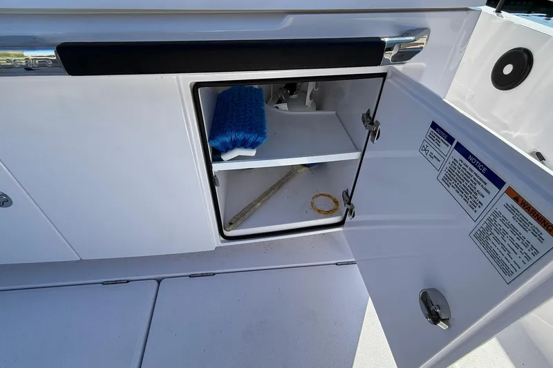 Slide: The Image of Open storage compartment on 2024 Axopar 37 boat with cleaning supplies inside. - 40