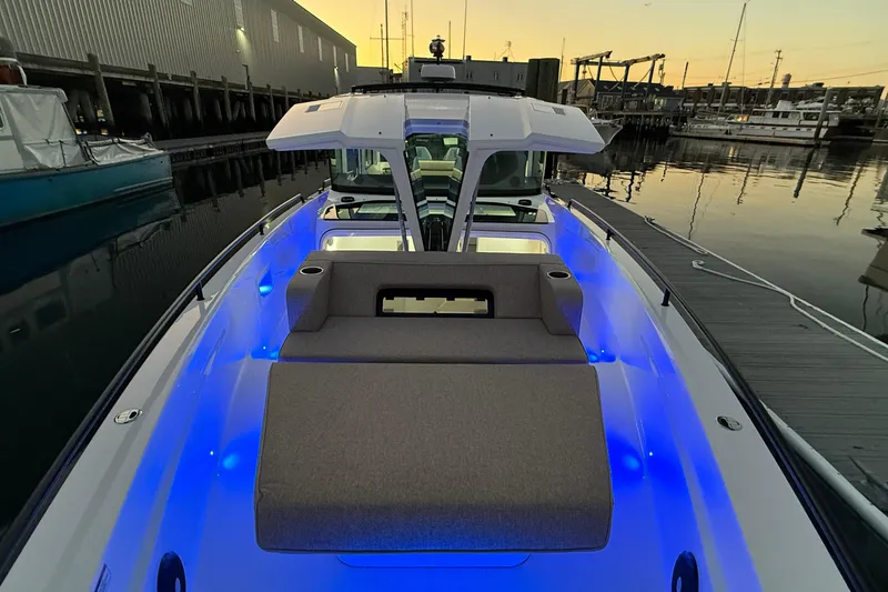 Slide: The Image of 2024 Axopar 37 boat with illuminated deck at sunset in marina. - 5