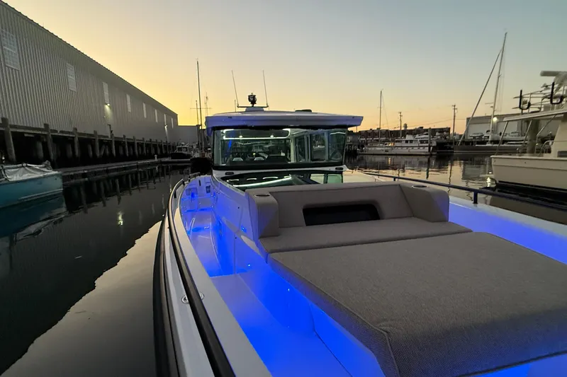 Slide: The Image of 2024 Axopar 37 boat with blue LED lights docked at sunset. - 7