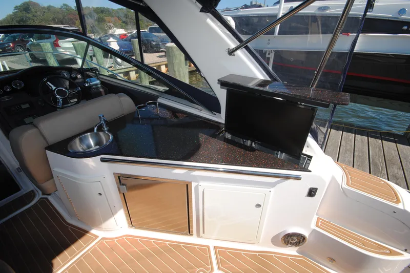 Slide: The Image of 2015 Regal 32 Express boat interior with kitchenette, sink, and TV. - 13
