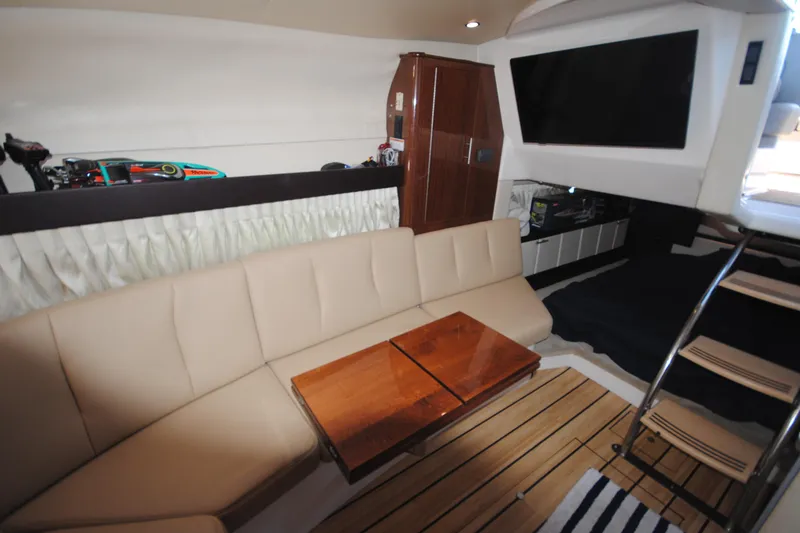 Slide: The Image of Interior of 2015 Regal 32 Express yacht with beige seating and wooden table. - 18