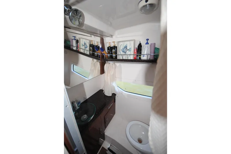 Slide: The Image of 2015 Regal 32 Express bathroom interior with sink, toilet, and storage shelves. - 21