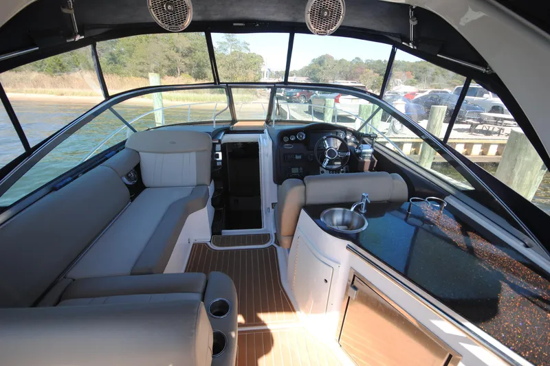 Slide: The Image of Interior of 2015 Regal 32 Express boat with seating, steering wheel, and kitchenette. - 7