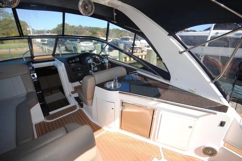 Slide: The Image of Interior of 2015 Regal 32 Express boat with helm, seating, and kitchenette. - 8
