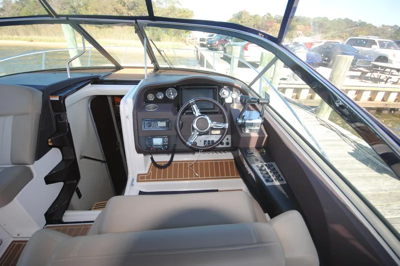 Slide: The Image of Cockpit of 2015 Regal 32 Express boat with steering wheel and control panel. - 9