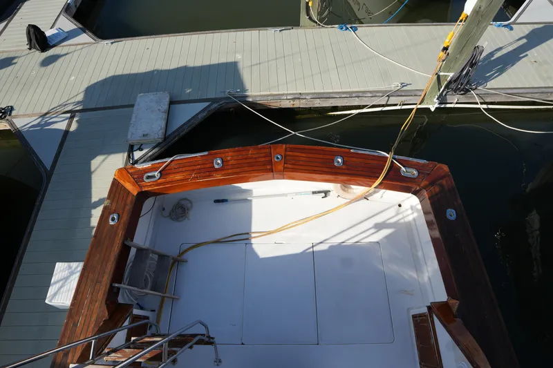 Slide: The Image of 1972 Viking 33 boat docked, featuring a wooden deck and mooring lines. - 12