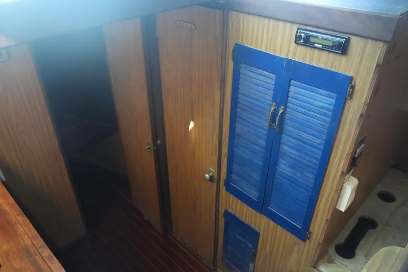 Slide: The Image of Interior of a 1972 Viking 33 boat with wooden paneling and blue cabinet doors. - 17