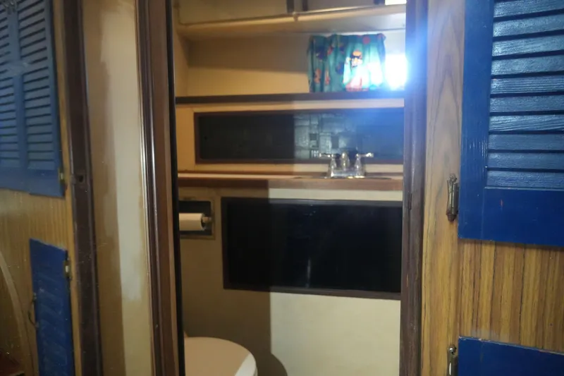 Slide: The Image of 1972 Viking 33 boat interior bathroom with sink, toilet, and wooden accents. - 18
