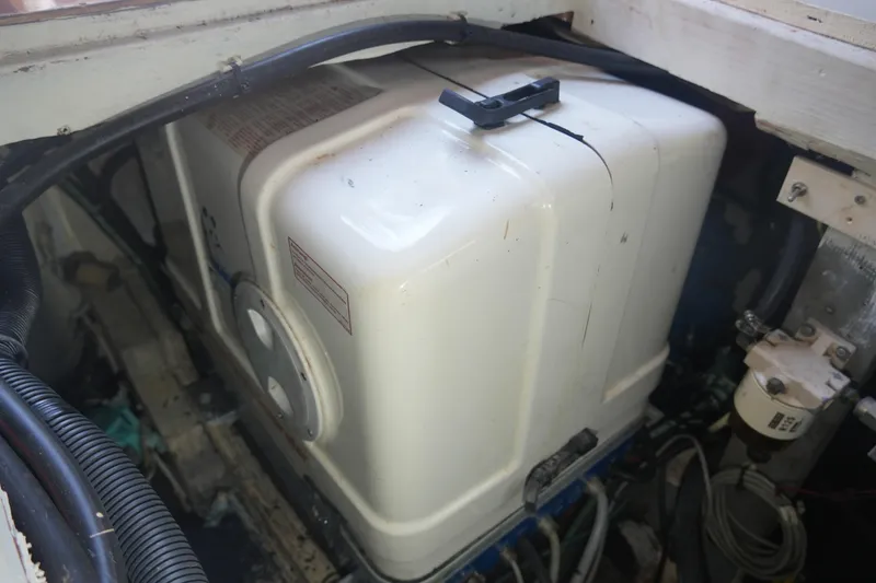 Slide: The Image of Engine compartment of a 1972 Viking 33 boat, featuring a white tank and wiring. - 33