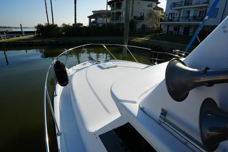 Slide: The Image of 1972 Viking 33 boat docked near waterfront homes, showcasing sleek deck design. - 6