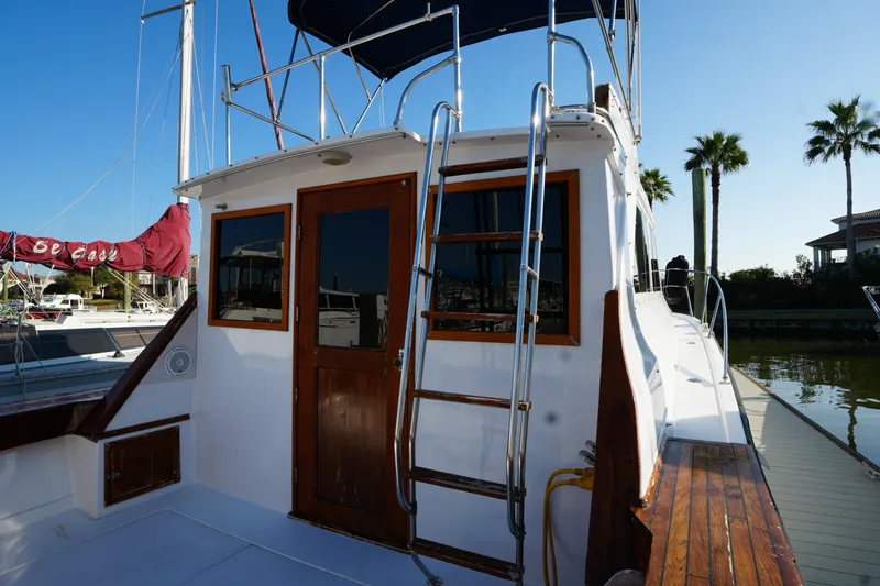 Slide: The Image of 1972 Viking 33 boat docked, featuring wooden accents and ladder, under clear blue sky. - 8