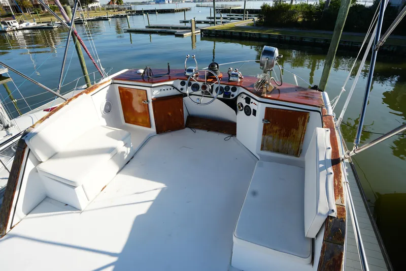 Slide: The Image of 1972 Viking 33 boat cockpit with white seating and wooden dashboard, docked at a marina. - 9