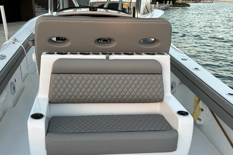 Slide: The Image of 2023 Valhalla Boatworks V-37 interior with quilted seating and cup holders by the water. - 18