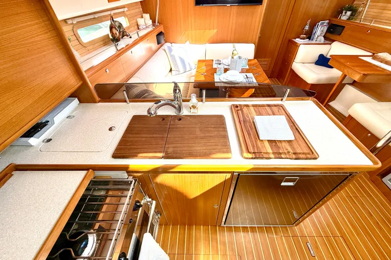 Slide: The Image of Luxurious Catalina 425 yacht interior kitchen with wooden cabinetry and modern amenities, 2020 model. - 32