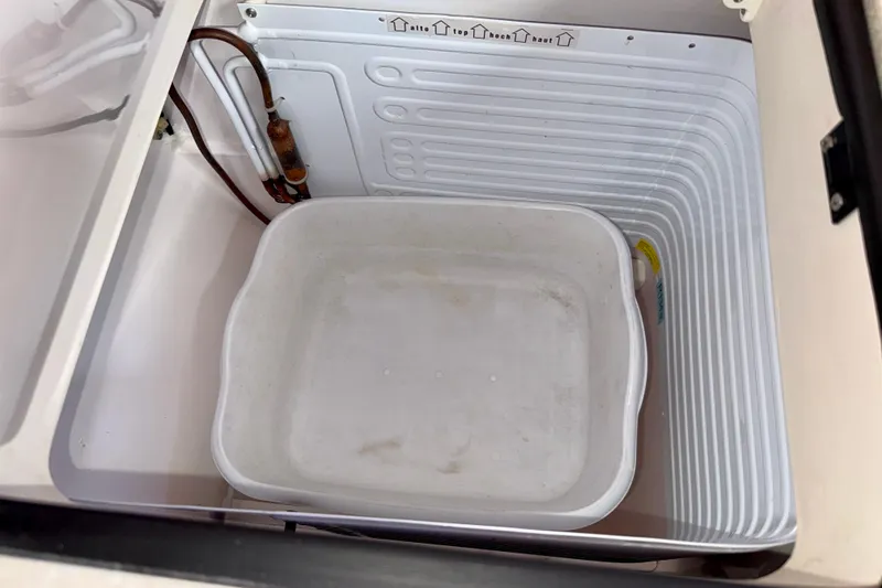 Slide: The Image of Open storage compartment in 2020 Catalina 425 boat with white container inside. - 36