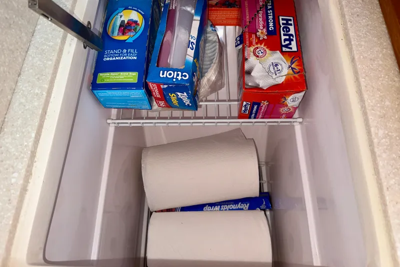 Slide: The Image of Storage compartment in a 2020 Catalina 425 with paper towels and kitchen supplies. - 37