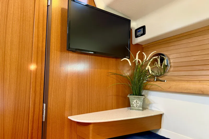 Slide: The Image of Interior of 2020 Catalina 425 yacht with TV, wooden paneling, and decorative plant. - 46
