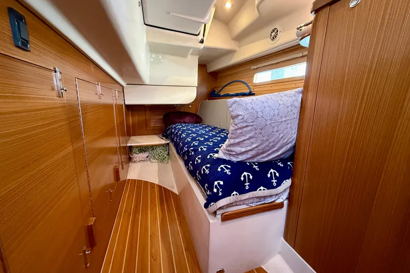 Slide: The Image of Cozy cabin interior of 2020 Catalina 425 sailboat with wooden finish and nautical bedding. - 50