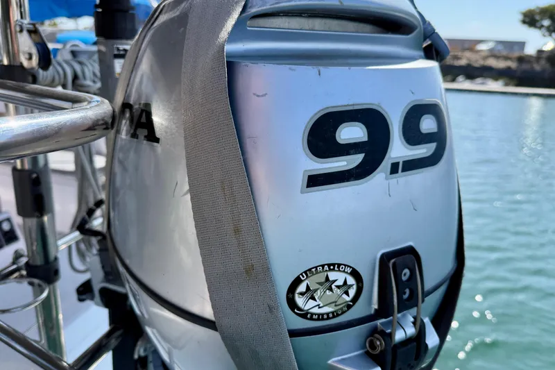 Slide: The Image of Outboard motor on Catalina 425 sailboat, 9.9 horsepower, ultra-low emission, docked by water. - 76