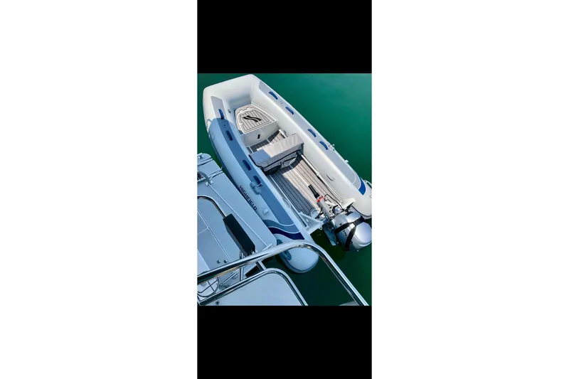 Slide: The Image of Catalina 425 (2020) yacht with attached inflatable boat on calm water. - 78