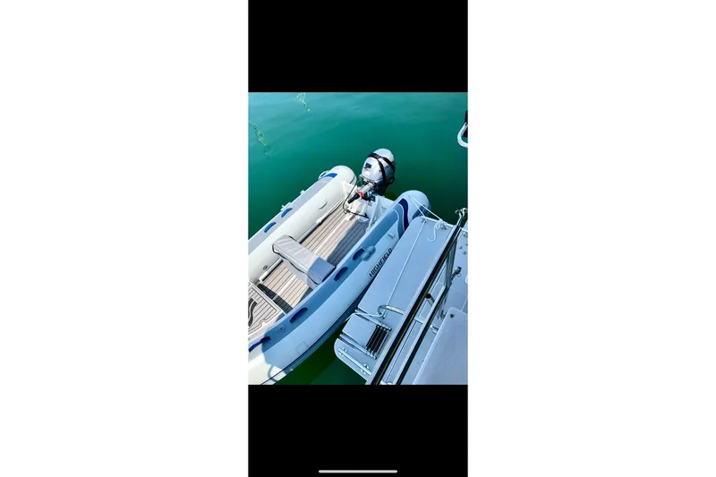 Slide: The Image of Inflatable boat docked beside Catalina 425 yacht, 2020 model, on calm water. - 79