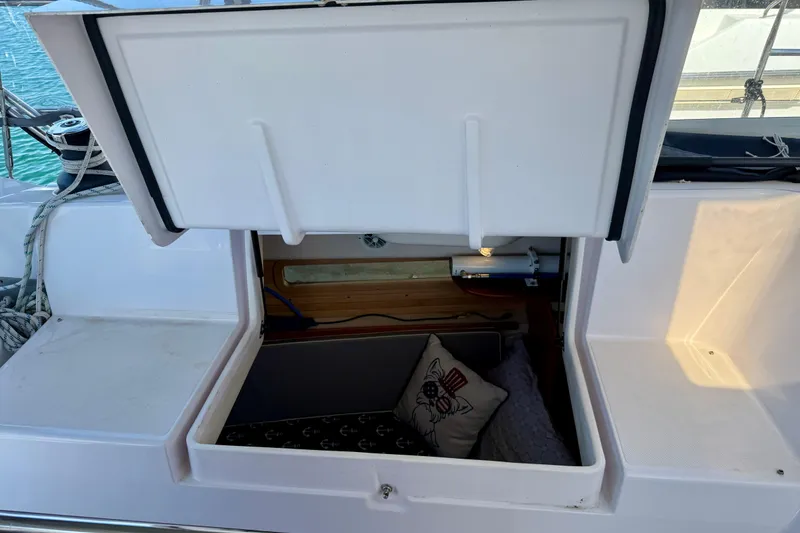 Slide: The Image of Open storage compartment on 2020 Catalina 425 sailboat with nautical-themed pillow inside. - 8